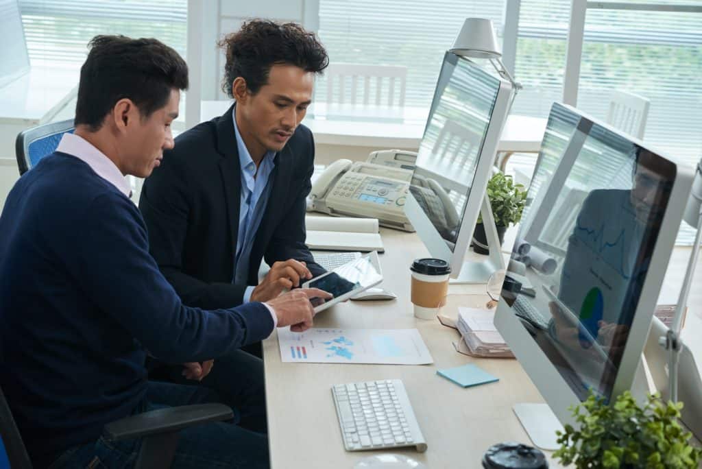 Businessmen working with finance data on tablet