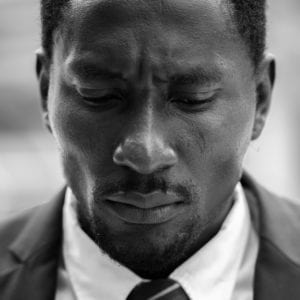 Face of stressed African businessman looking sad and depressed in black and white