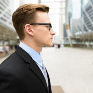 Side view young handsome Caucasian businessman in front of modern building at Bangkok city