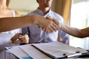 Young woman and financial adviser shaking hand